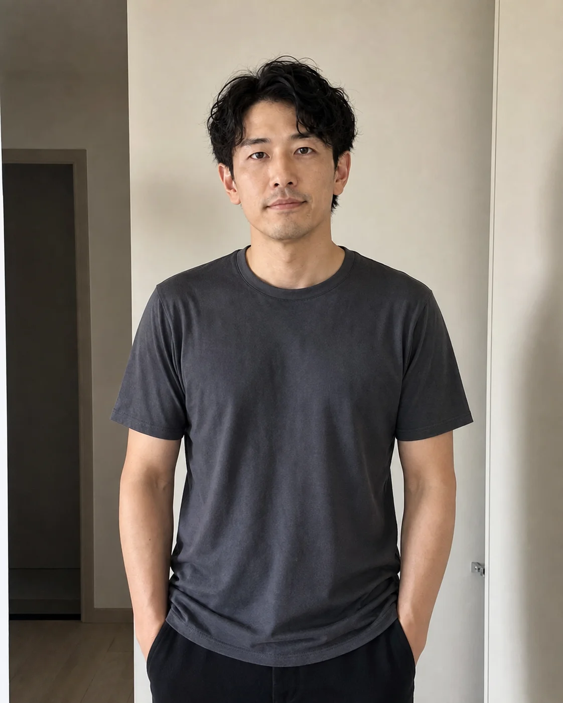 自宅の室内で無地のTシャツを着た日本人男性のスナップ写真